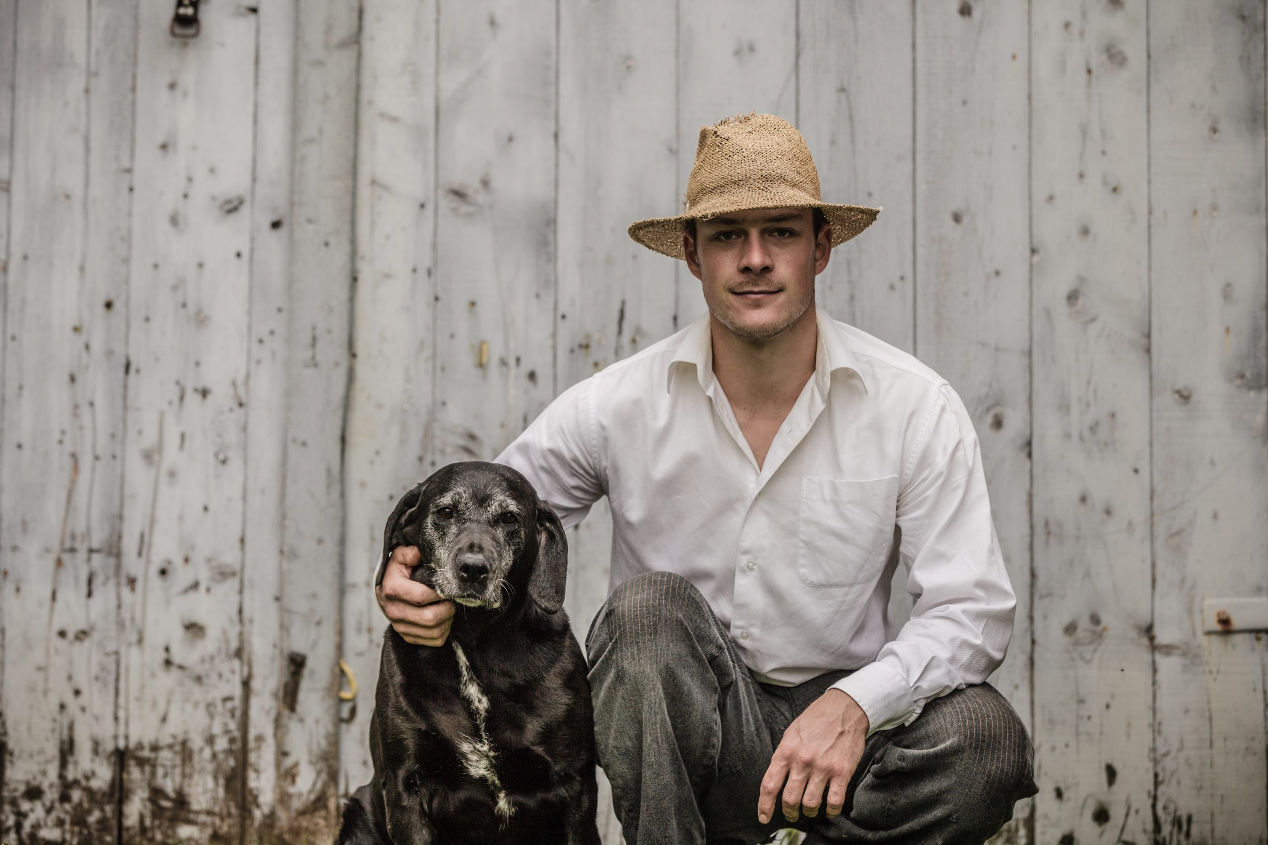 Image of a man wearing a cowboy hat beside a dog